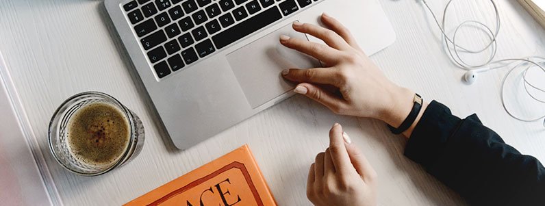 hands on a table using laptop