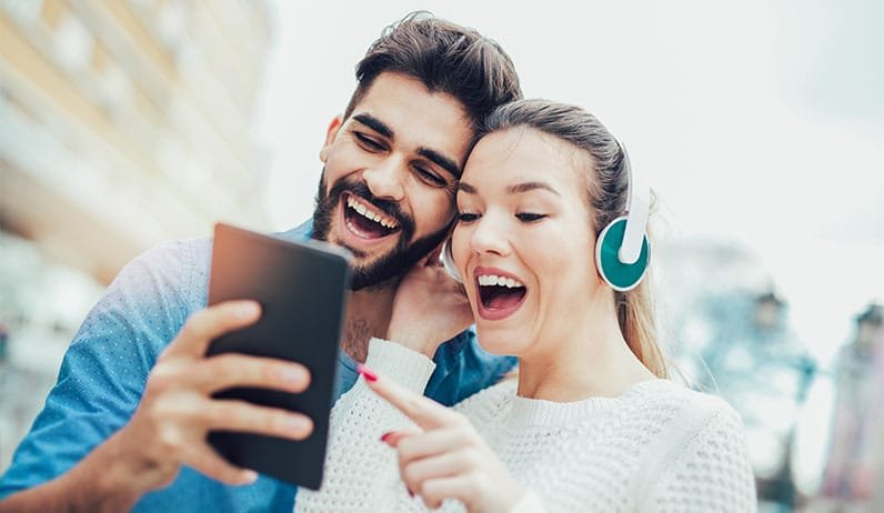 happy couple using tablet and headphones