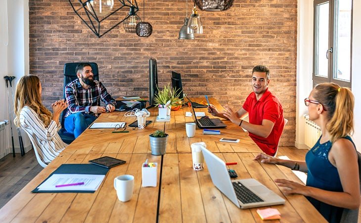 group of people working and chating with laptops