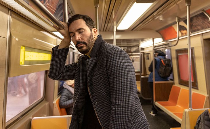 man falling asleep in the subway
