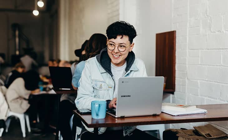 smiling woman with a laptop in a cafe
