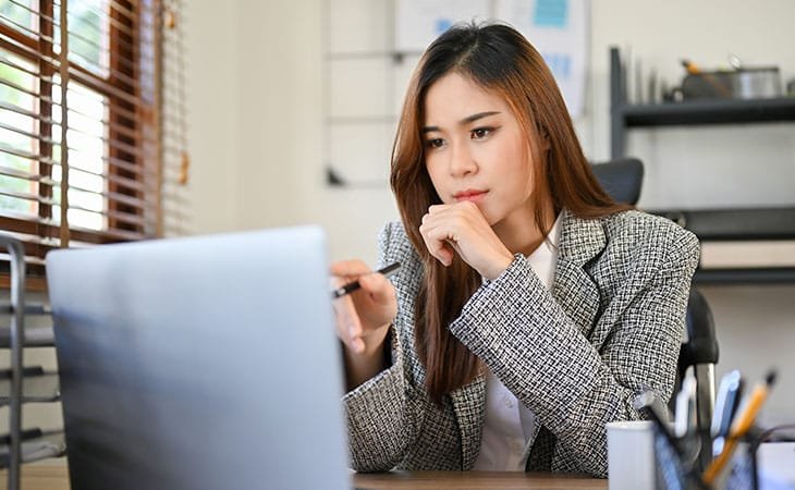 woman working and thinking with a laptop