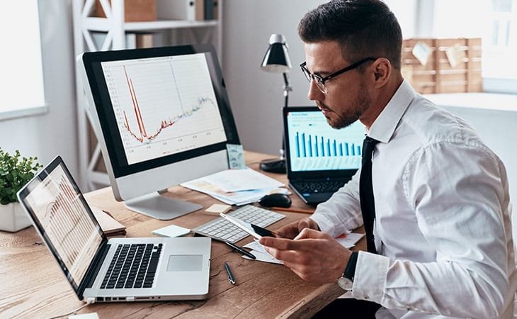 man analyzing data in several screens