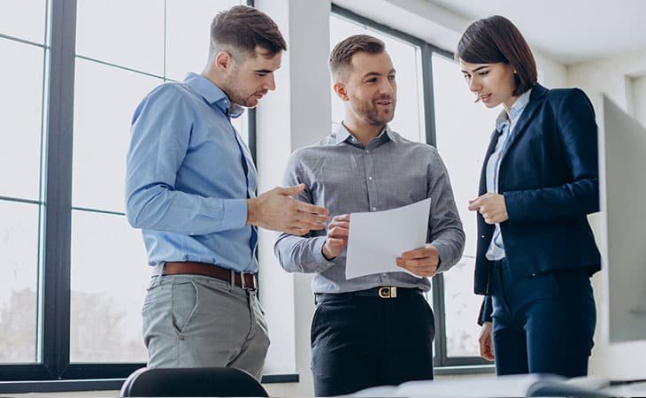 three coworkers reading a paper