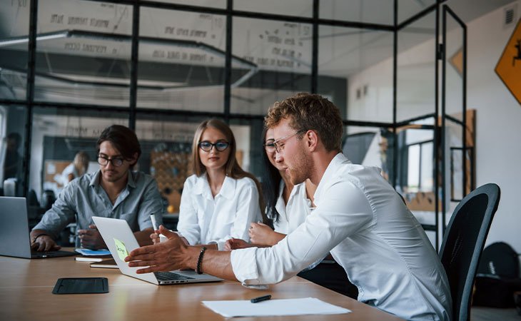 Program Manager Job Description: Essential Skills Guide Independent Recruiter LLC | Staffing Agency three-office-workers-man-pointing-laptop