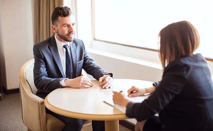 woman interviewing a man in a round table