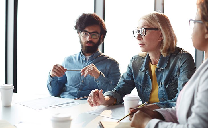 workers-talking-meeting-table
