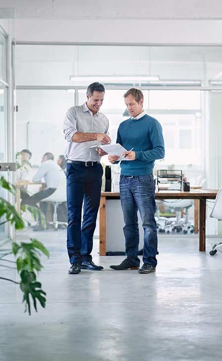 coworkers-talking-papers-office