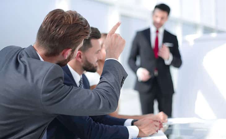 man-asking-question-potining-meeting