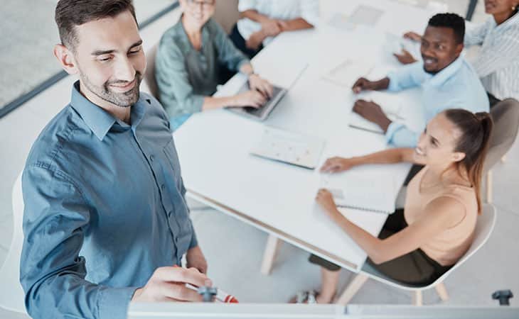 smiling-man-writes-board-meeting