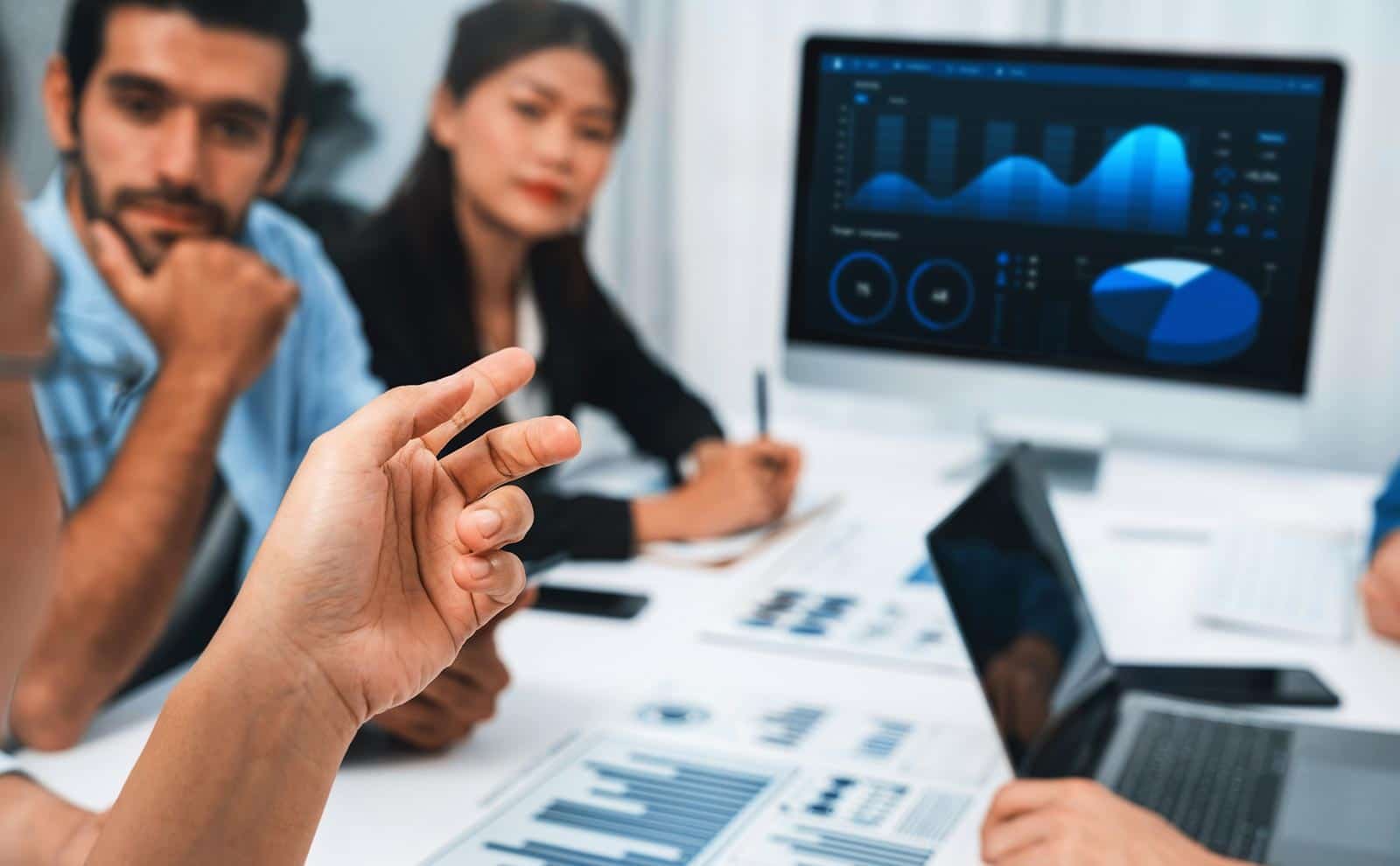 detail-hand-pointing-screen-people-meeting