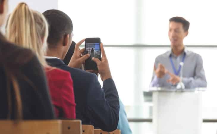 man-giving-talk-people-man-taking-picture