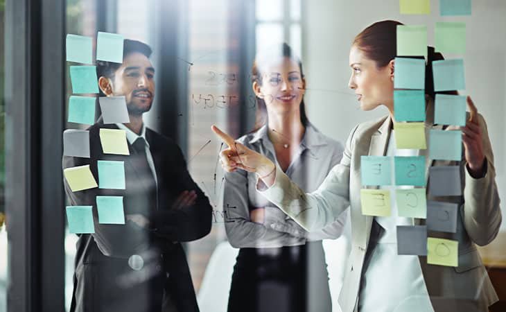 people-discussing-post-its-glass