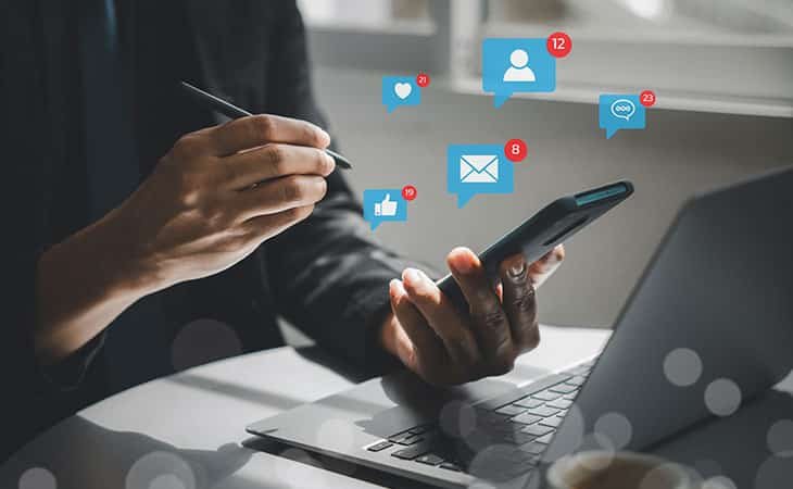 detail of persons hands using a pen and social media icons
