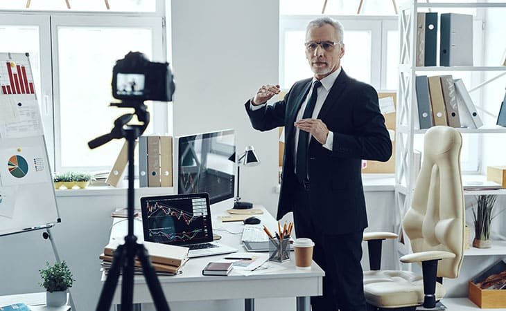 man in a suit explaining things to the camera