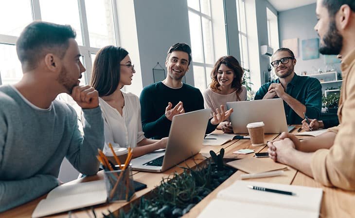 people talking at a table inside an office
