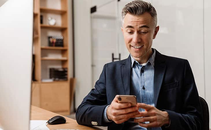 surprised and smiling man using his phone