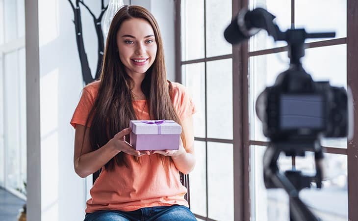 woman holding a gift and looking at the camera
