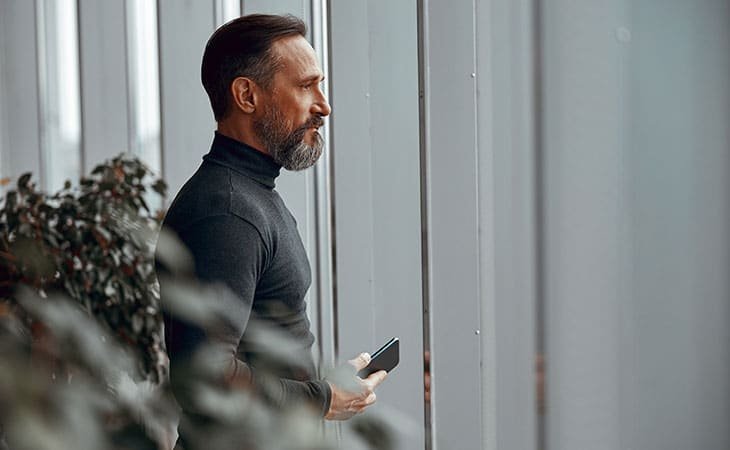 a thoughtful man with his phone in his hand