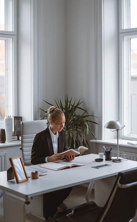 a woman reading a book in an office