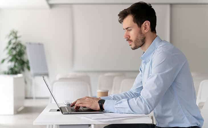 man using a laptop in a white room