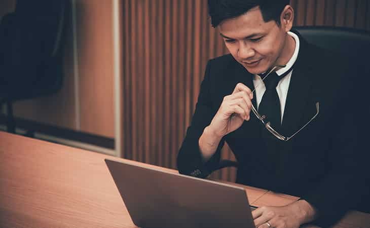 man wearing a suit and holding his glasses