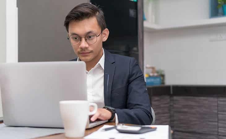 man wearing glasses and using a laptop