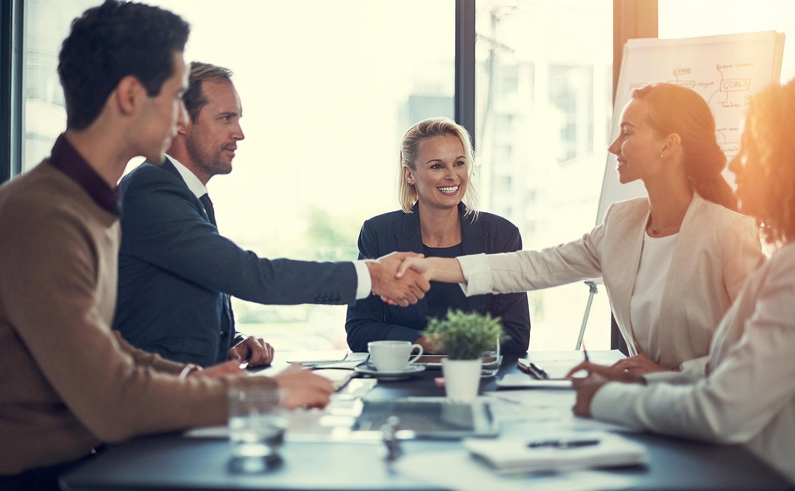 several people at the office in a meeting and shaking hands
