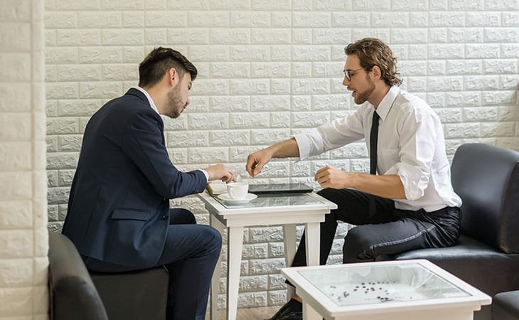 two men having a conversation at a table