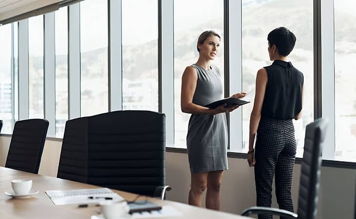 two women talking at a corporate office
