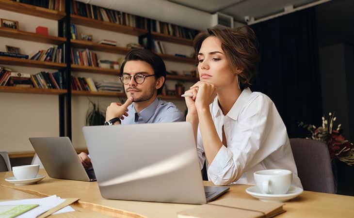 couple-thinking-using-laptop