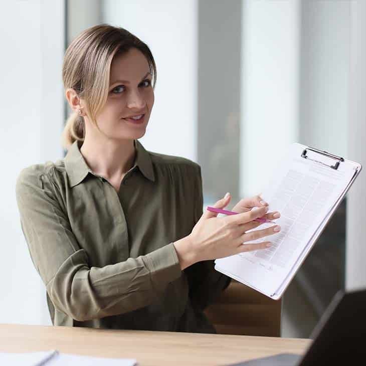 woman showing papers looking at the camera