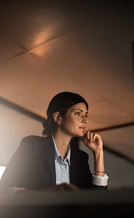 woman with her hand in her chin looking at a computer