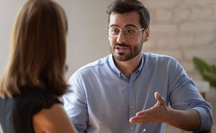 a man explaining something to a woman and making gestures