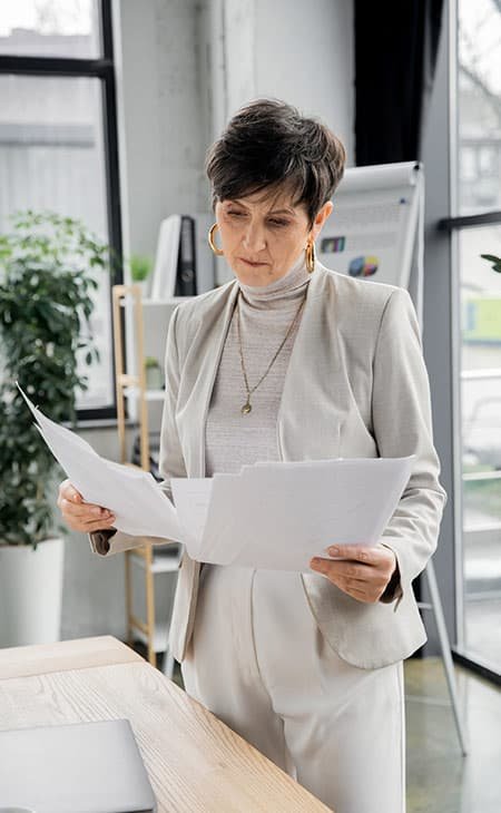 a woman holding and looking at papers