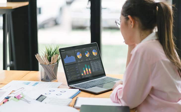 a woman looking at charts in her laptop