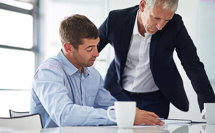 two-business-men-talking-papers-mug