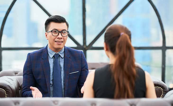 man with his hands open while talking to a woman