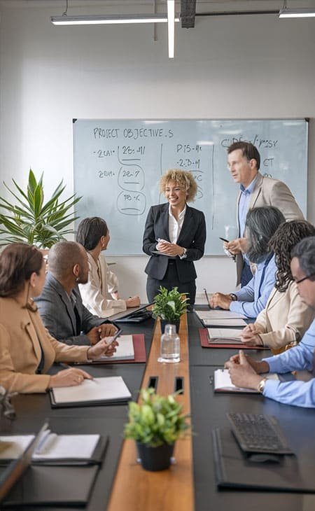 people in a meeting with a board behind