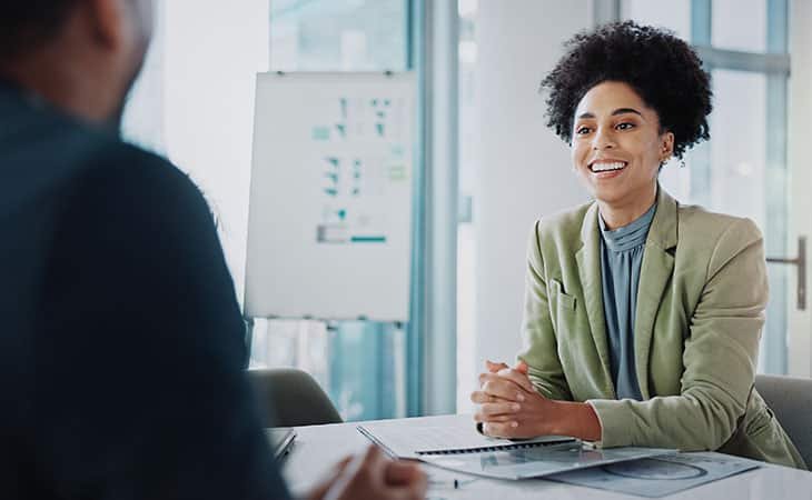 smiling woman talking to a man in the office