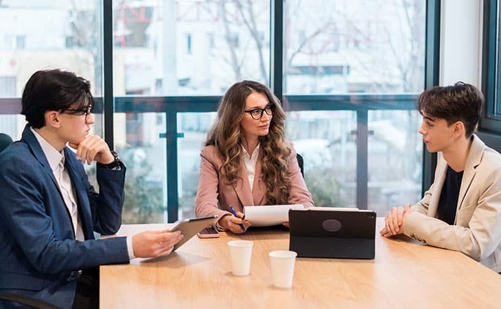 three people having a meeting in an office