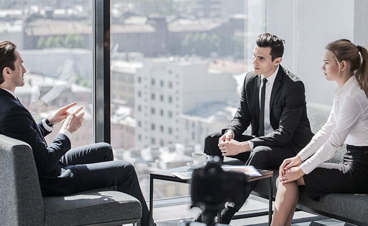 three people talking at the office near the window