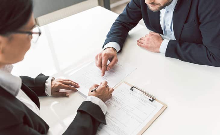 two people pointing at a document