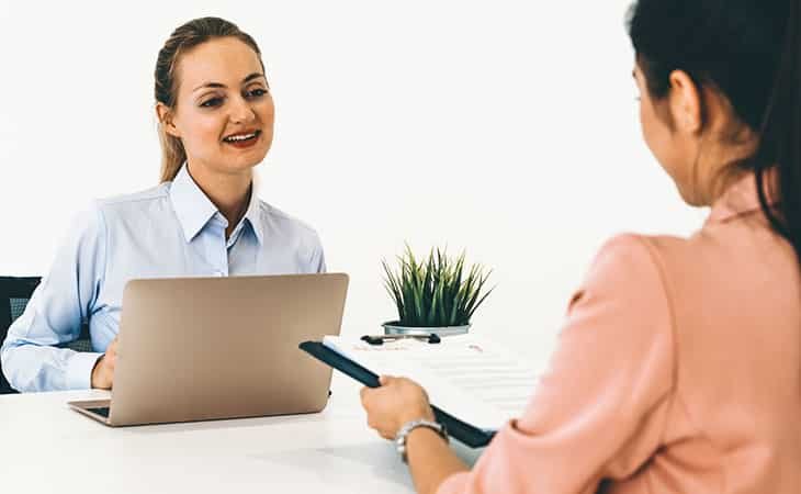 two women talking about documents