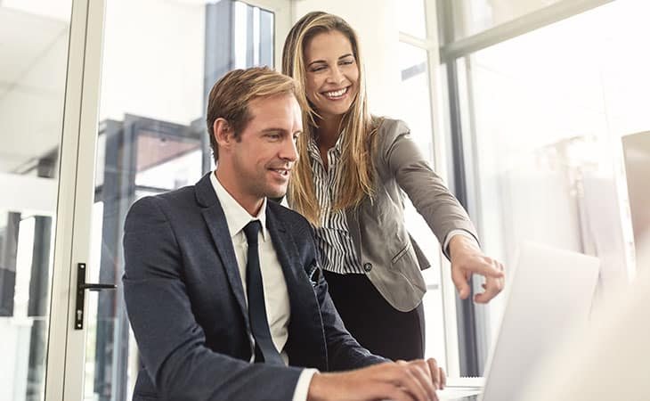 woman and man talking and pointing at a laptop